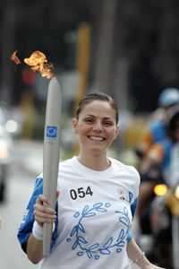 A torchbearer carries the flame during the 2004 Athens Olympic Torch Relay.