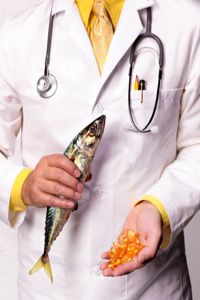 Doctor holding a fish and omega-3 pills. 