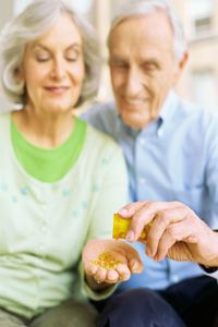 Older couple taking omega-3 pills. 