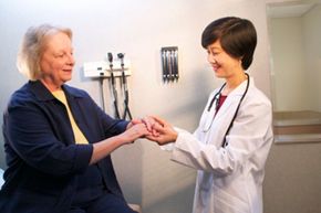 Doctor examining patient's hands. 