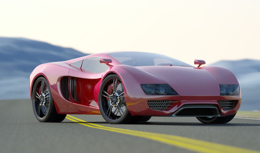 An ominous looking red sports car parked on an open road.