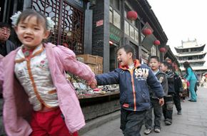 Children hold hands as they walk through the ancient city of Pingyao.