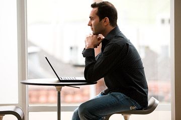 young man at table with computer