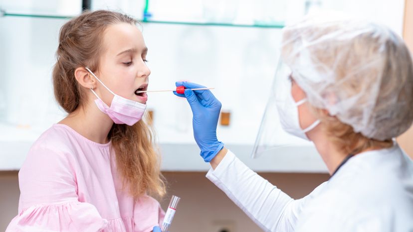 A nurse taking a swab from a girl's mouth. Ready to undergo the oral HIV test.