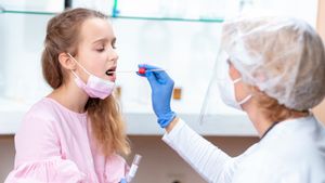 A nurse taking a swab from a girl's mouth. Ready to undergo the oral HIV test.