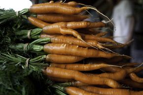 一堆洗净的有机胡萝卜等待在佛蒙特州的Clear Brook有机农场冷藏。“border=