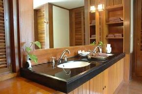 A bathroom with two sinks, featuring prominent wooden custom cabinetry.&nbsp;