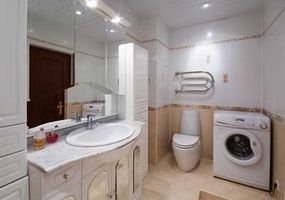 A combination bathroom featuring a toilet and a clothes washing machine.&nbsp;
