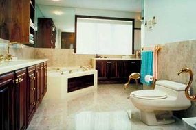 A modern bathroom with marble surfaces, gold finishings, and two countertops.&nbsp;