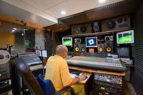 Sound engineers combine a film's dialogue and sound effects in a post-production studio.