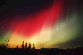 A glowing red aurora borealis appears in Denali, Alaska.