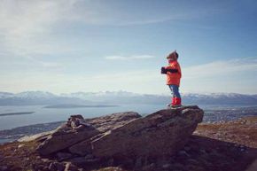 特罗姆瑟（Tromsø）的寒冷白天地形暗示了晚上闪耀的天空。“border=