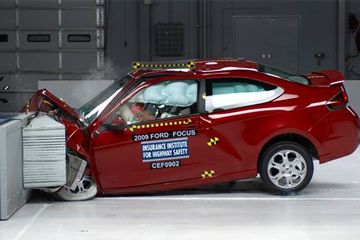 A 2009 2-door Ford Focus is seen in a 40 MPH frontal offset test at the IIHS test center in Virginia.