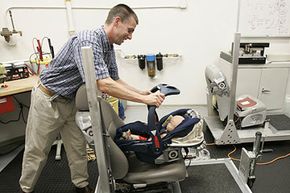 Takata technical manager Greg Stanley places an infant carrier on a seat for testing in Farmington Hills, Mich.