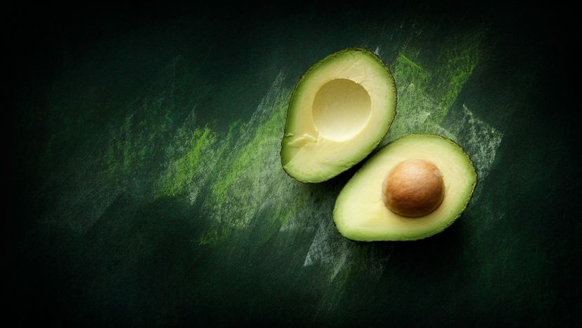 avocado cut in half on countertop with seed visible