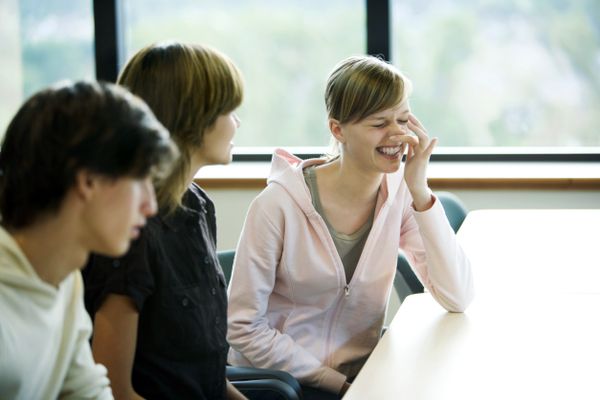 A young woman tries to prevent a sneeze by placing her finger near her nose.