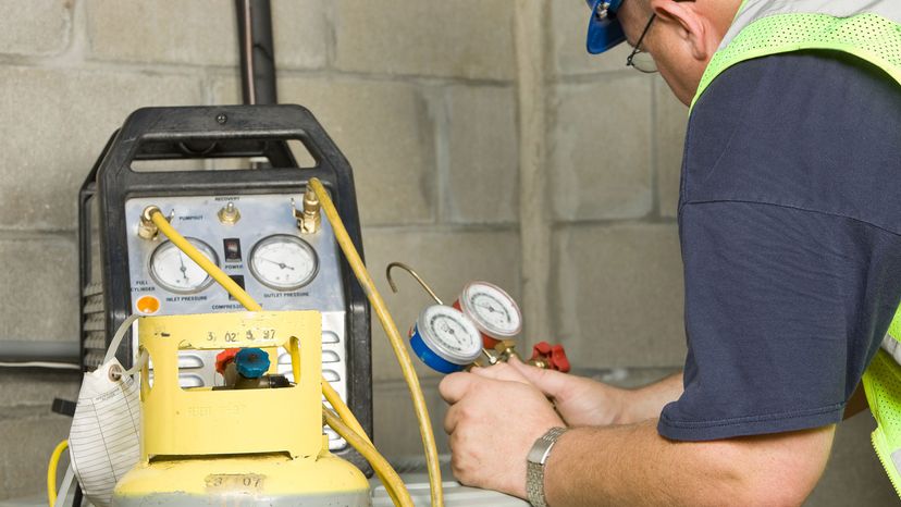 HVAC technician removing refrigerant from an A/C unit.