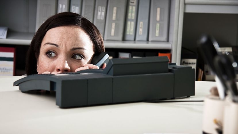 woman hiding by desk