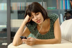 年轻女子看视频iPod”width=