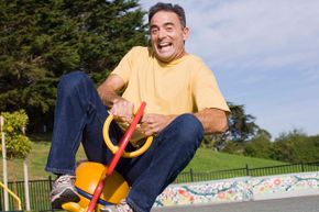 Adult man on child's playground equipment