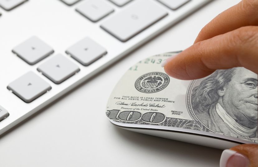 Hand on mouse with 100 dollar bill on it symbolizing affiliate marketing.