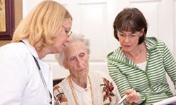 An elderly woman consults with her doctor and daughter about long-term care options.