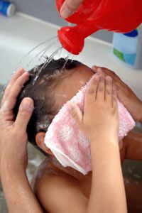 little kid in the bath with a washcloth
