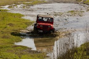SUV driving through muddy terrain. 