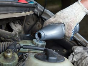 A mechanic fills the brake fluid reservoir