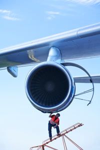 A flight mechanic attends to a modern gas turbine engine.