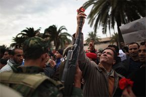 An image of peace from 2011's Arab spring. Here, a demonstrator places a flower in the barrel of a soldier's rifle after the ousting of Tunisia's then-president Zine al-Abidine Ben Ali. The Arab spring also created opportunities for groups like al-Qaida.