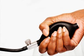 Nurse's hand squeezing bulb on blood pressure equipment