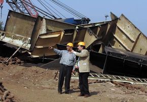 A Gujarat Maritime Board official and a shipbreaking captain discuss the details in front of a ship that will be scrapped, salvaged and recycled.