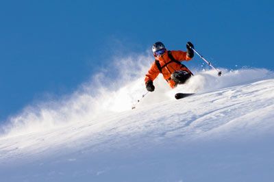 Person speedily performing extreme sport in powder snow.