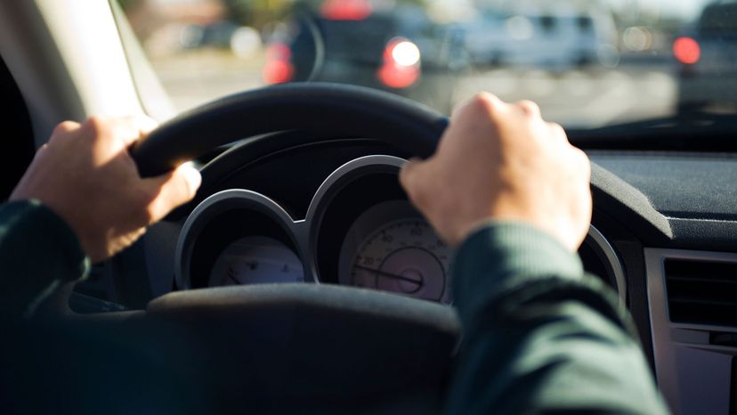 A driver has both hands on the steering wheel.