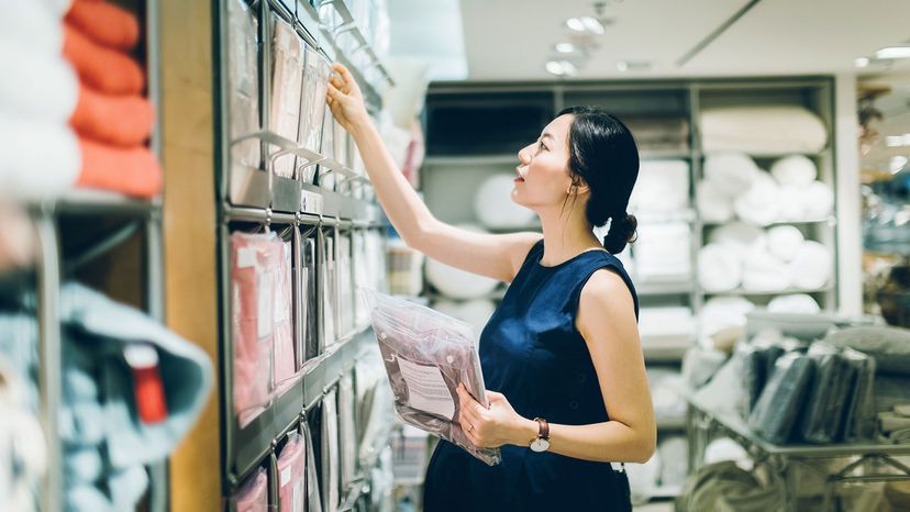 Smiling young pregnant woman shopping for home necessities in shop