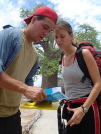 Rob and Amber pause to read a route marker while making their way to Botswana.
