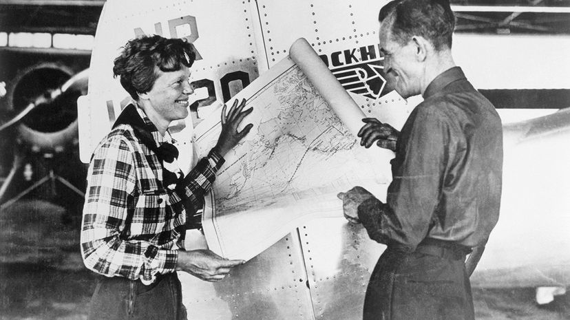 Pilot Amelia Earhart and her navigator Fred Noonan hold a map of the Pacific that shows the planned route of what became their final flight. Bettmann Archive/Getty Images