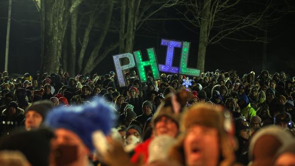 Men illuminated in a night celebration crowd.