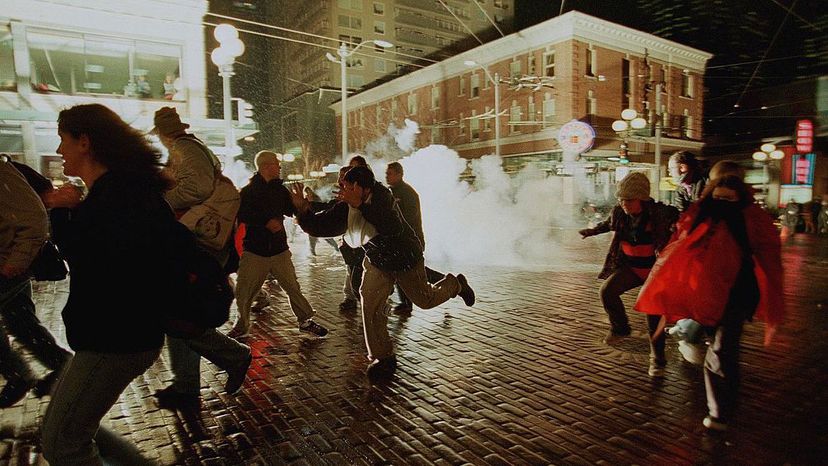 Anti-WTO protestors run from exploding tear gas grenades as riot police continued to battle World Trade Organization demonstrators during the Battle in Seattle, December 1999. KIM STALLKNECHT/AFP/Getty Images