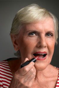 Senior woman applying lipstick, portrait, close-up
