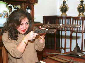 A Lebanese antique dealer examines a pair of 17th century gold and silver studded guns at a flea market that opened in the war-devastated city center of Beirut.