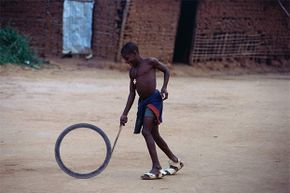 A young Cameroonian boy enjoys bowling a hoop -- just like children have for centuries.