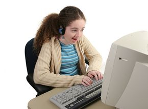 Teenage girl enjoys instant messaging on her desktop computer.