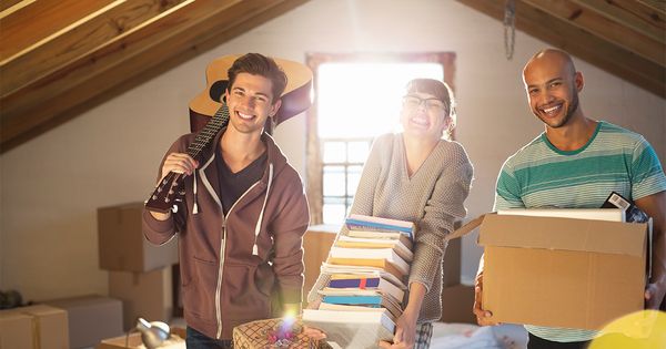 Friends unpacking boxes in attic