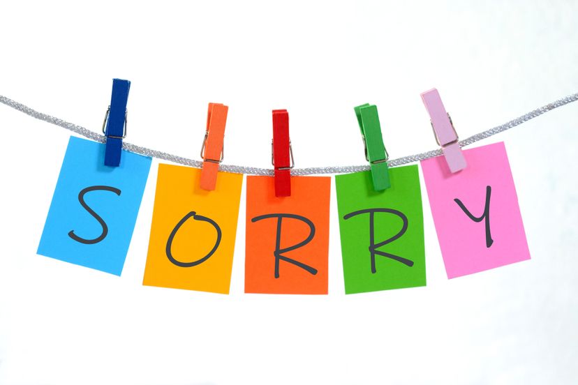 Sorry text written on paper hanging on clothesline.