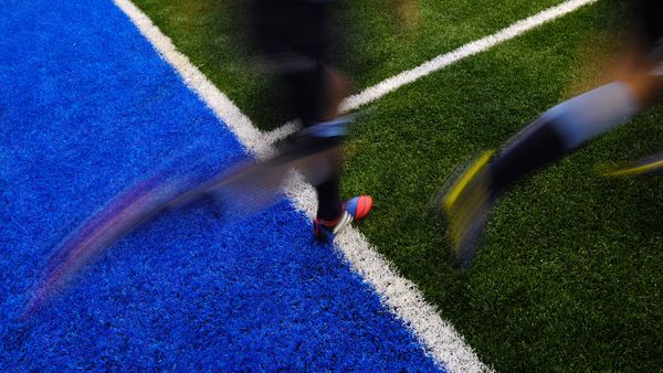 artificial turf field with rugby players on it