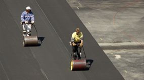 Workers install artificial turf at Clark University