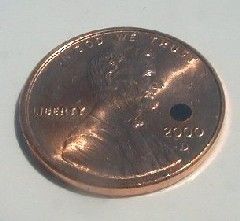 The dot above the date on thispenny is the full size of the artificial silicon retina.