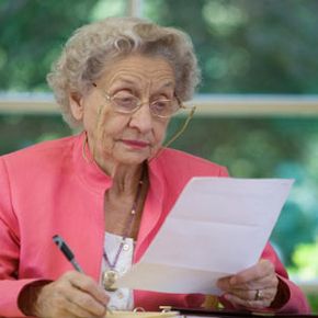 older woman looking over contracts